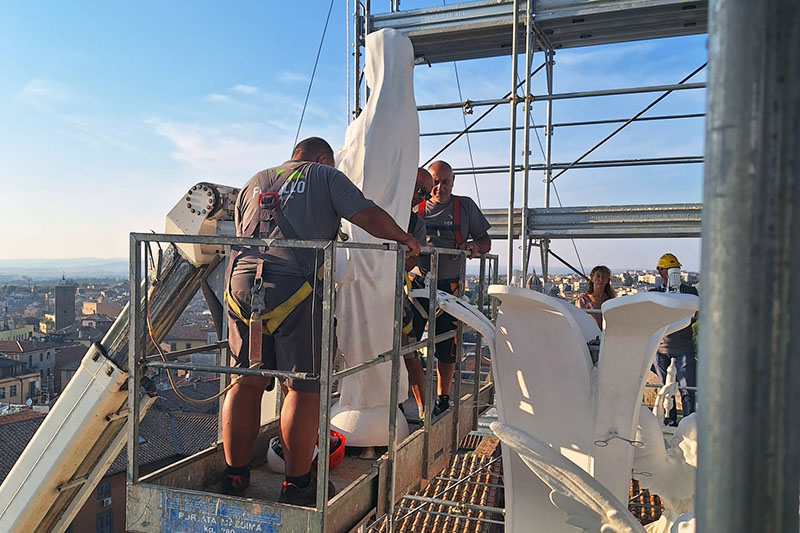 La statua della santa raggiunge la cima della Macchina