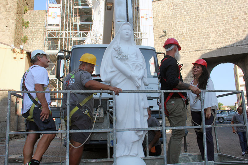 La statua della santa raggiunge la cima della Macchina